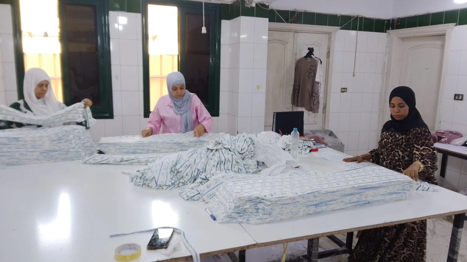 Team members preparing fabric at a worktable