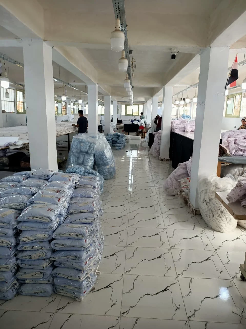 Packed garments stacked beside worktables in the finishing area